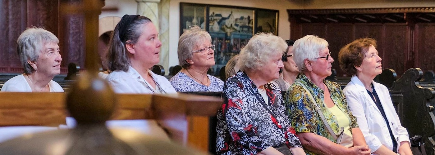 Zu sehen sind Teilnehmer des Frauenkreises auf einer Kirchenbank